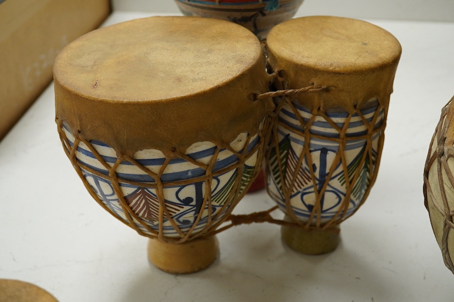Five African drums; a Djembe, 60cm high, together with four small North African pottery double drums. Condition - fair to good.